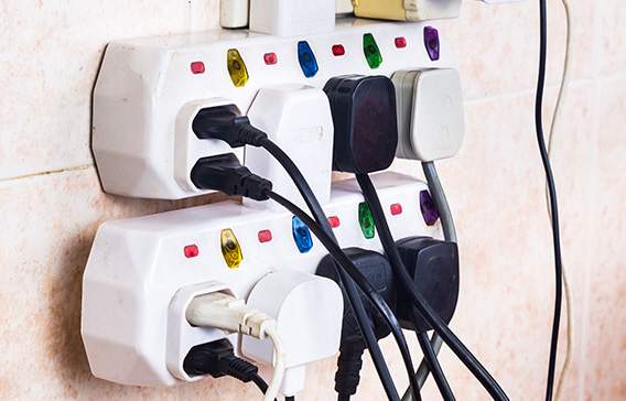 Multiple electrical plugs in adaptors causing risk of overload and danger